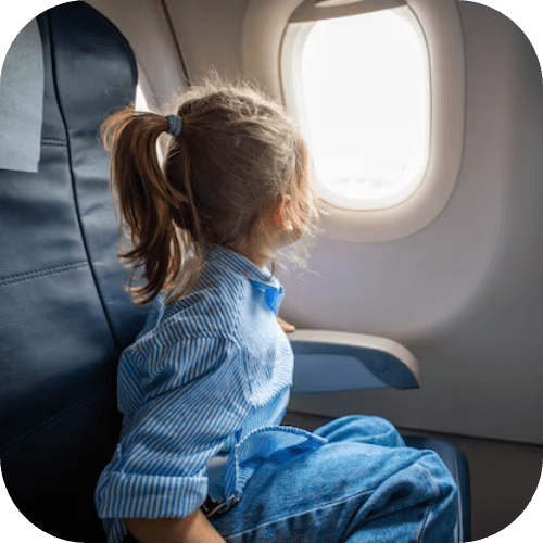 Enfant regardant par le hublot d'un avion en plein vol